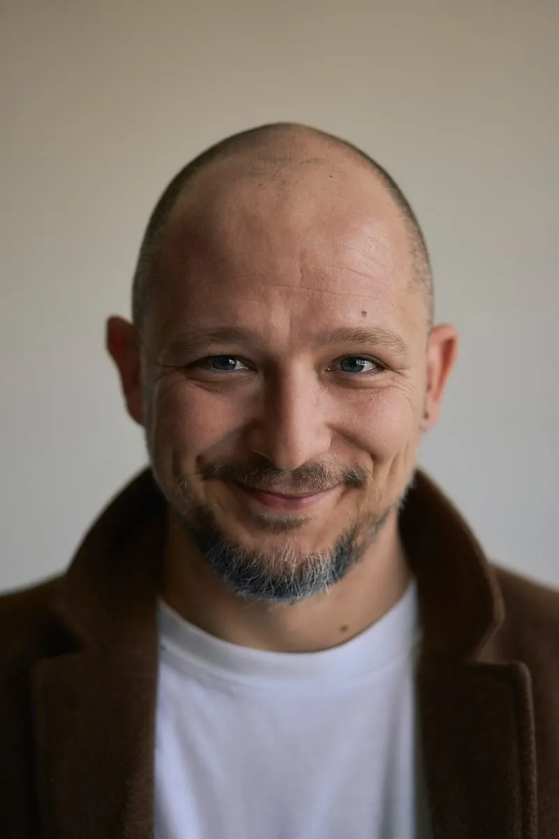 Portret uśmiechniętego mężczyzny w brązowym płaszczu