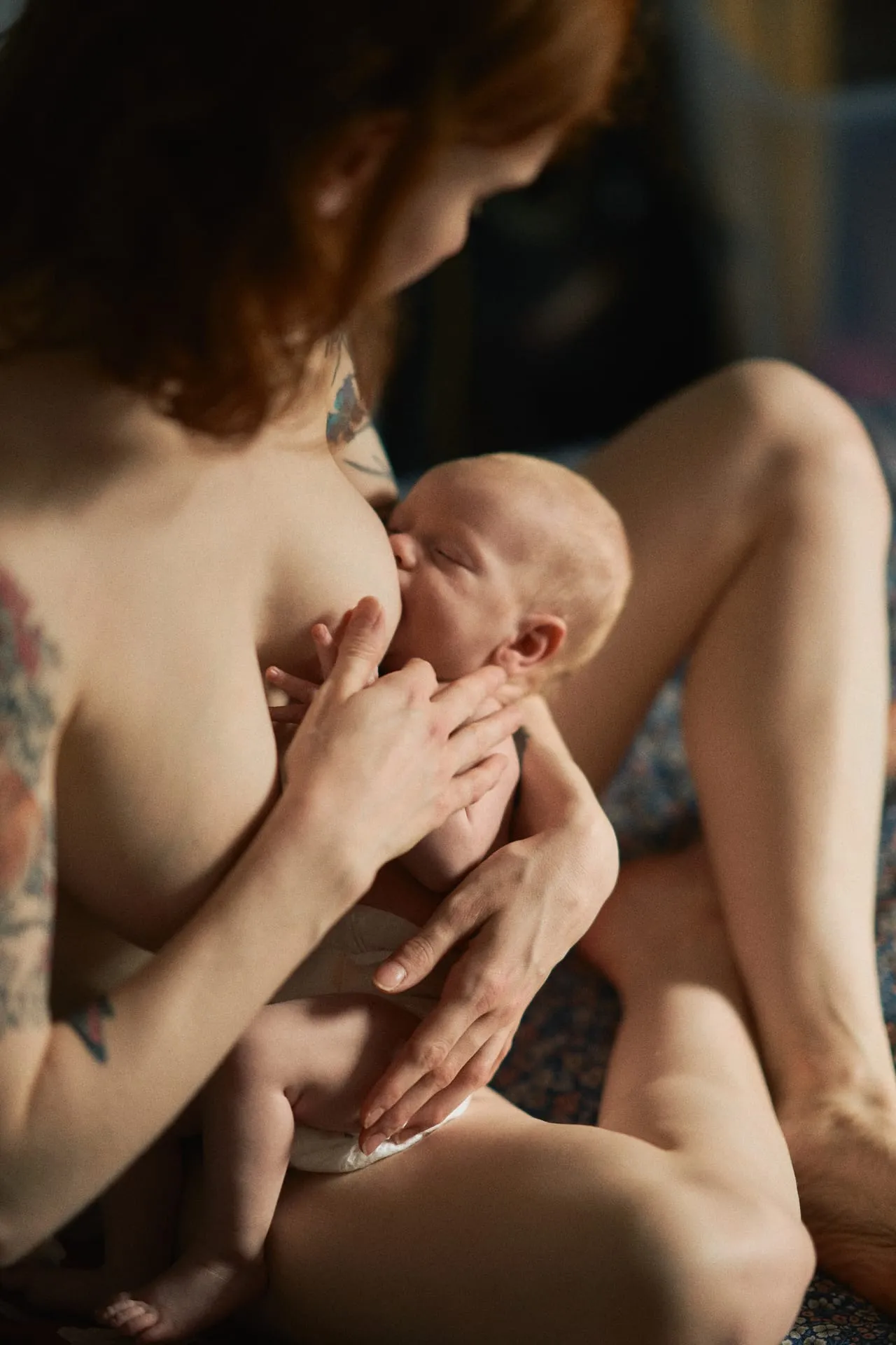Mama karmiąca noworodka w miękkim domowym świetle