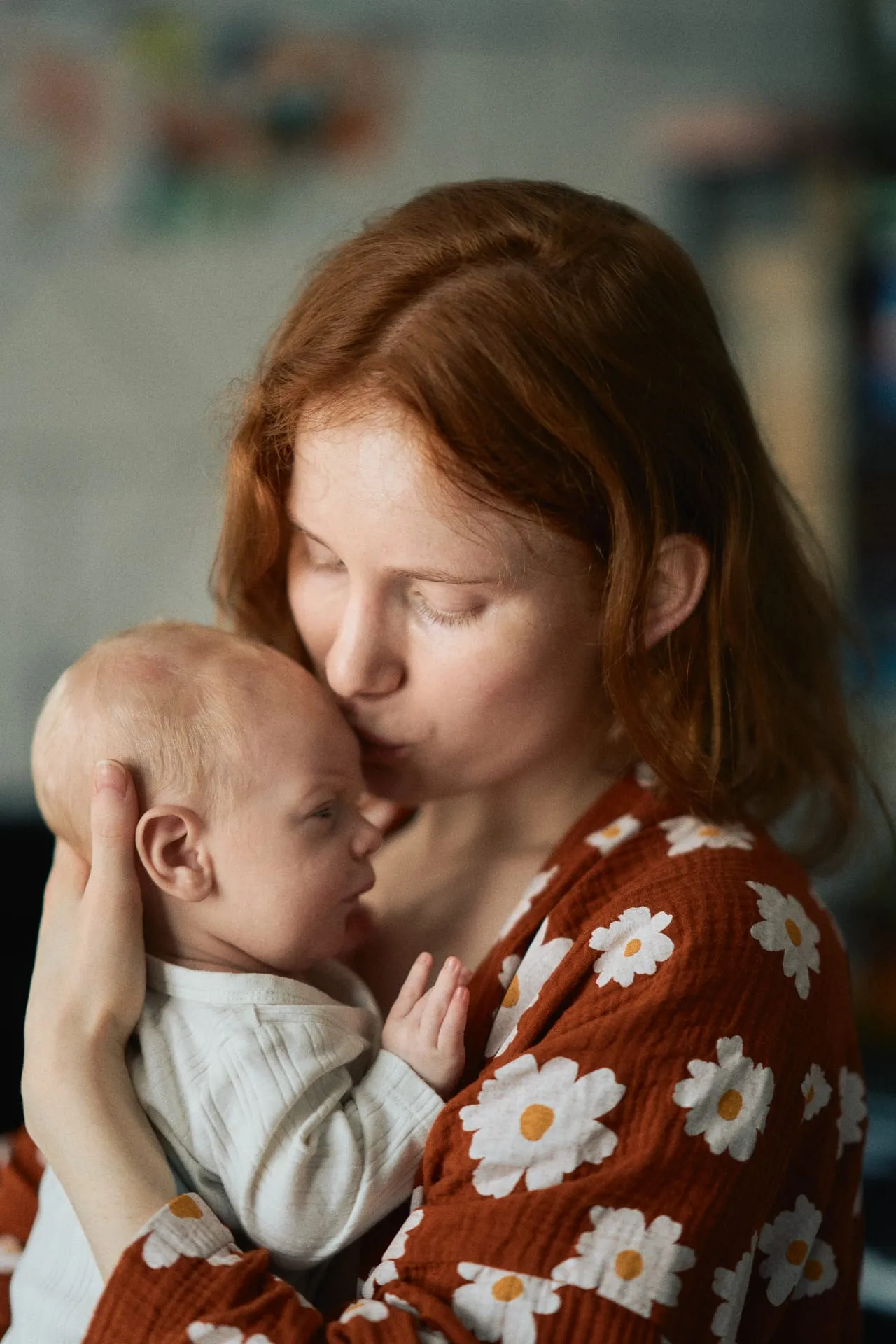 Mama całująca niemowlę w czoło