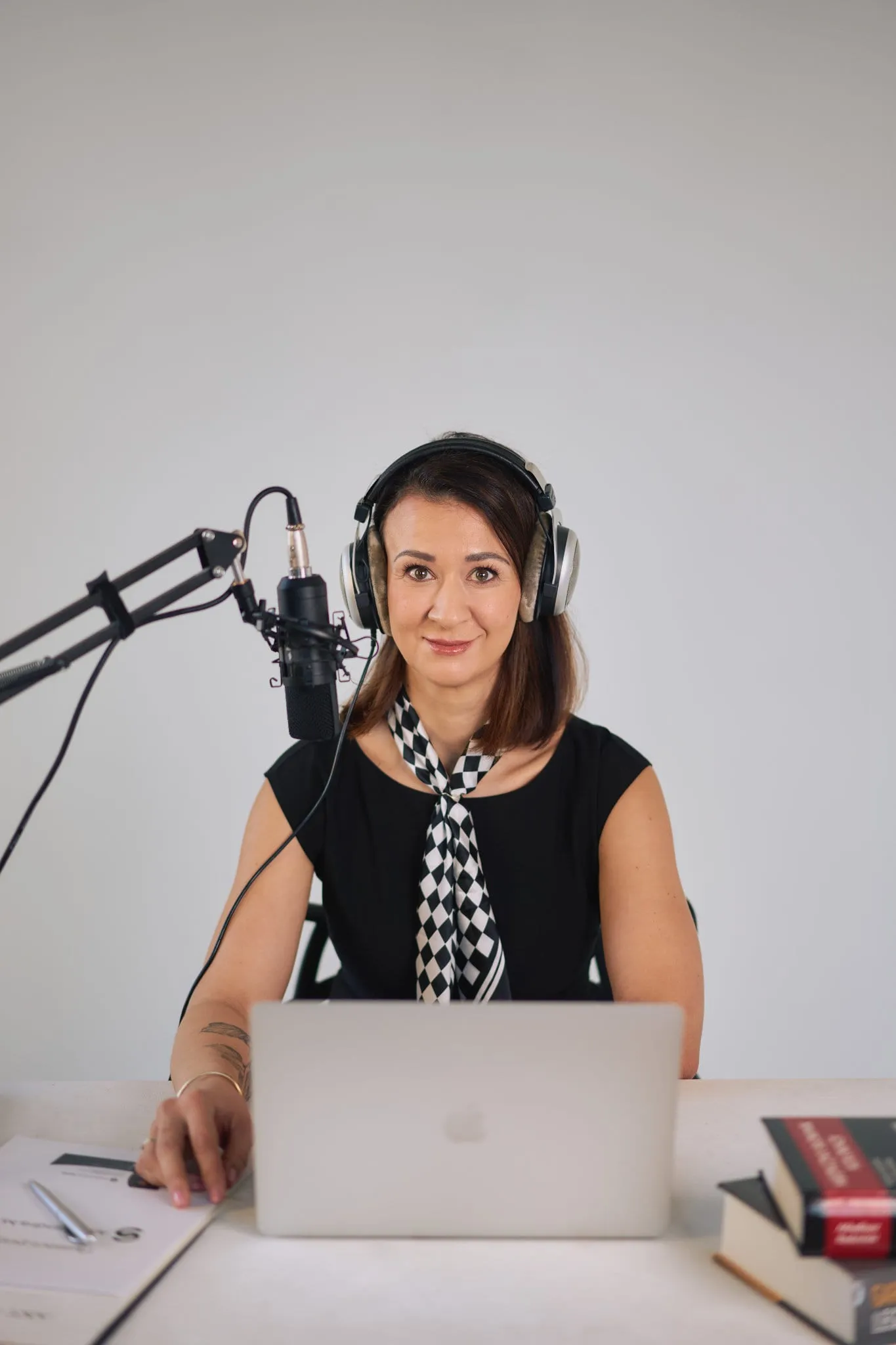Kobieta w słuchawkach przy mikrofonie podcastowym - sesja wizerunkowa