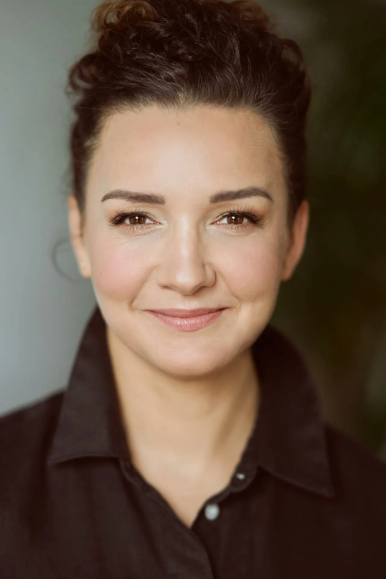 Portret uśmiechniętej kobiety w brązowej koszuli