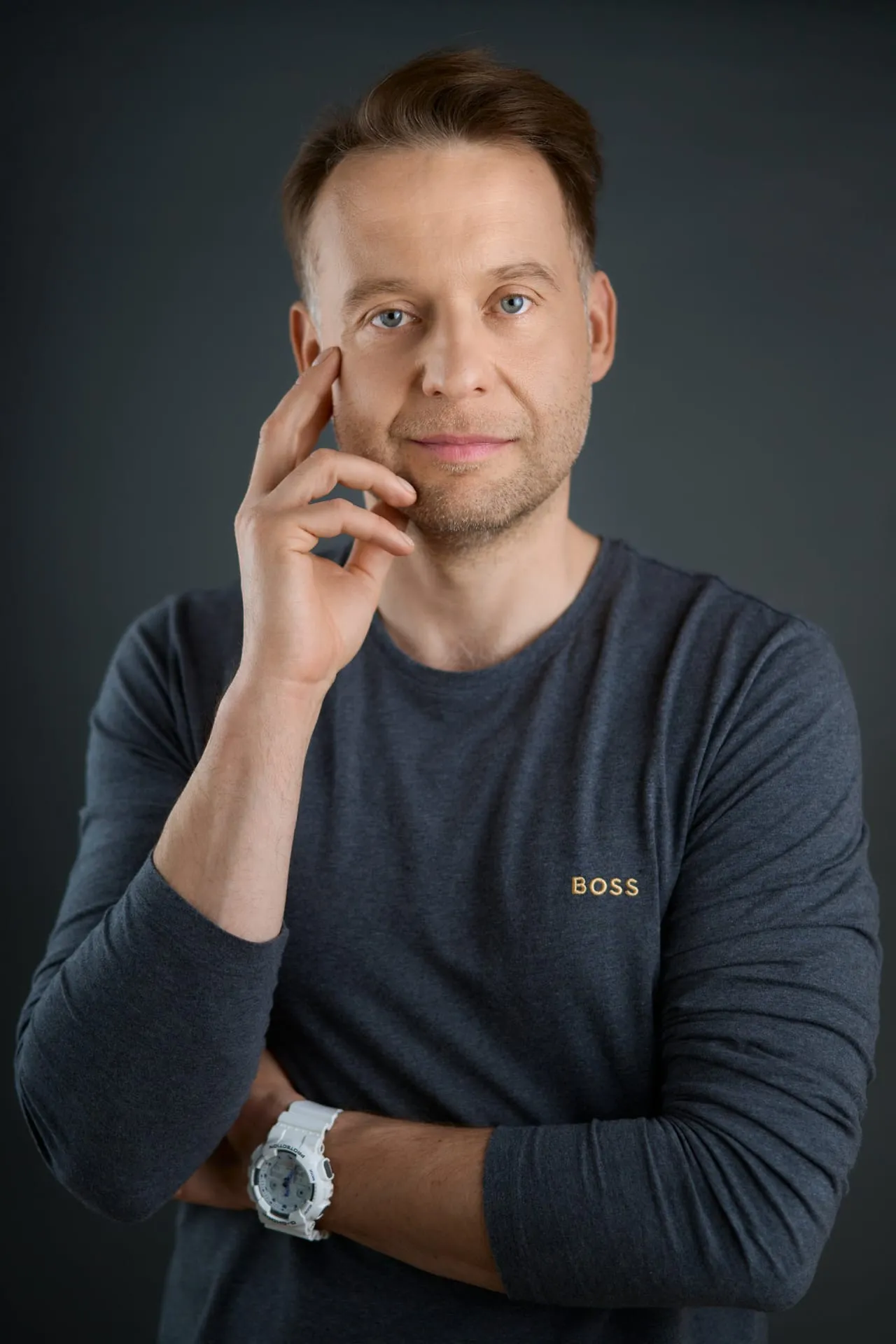 Portret mężczyzny w granatowej koszulce na ciemnym tle